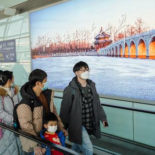 Des passagers à l'aéroport de Pékin. [Keystone - EPA/Wu Hao]