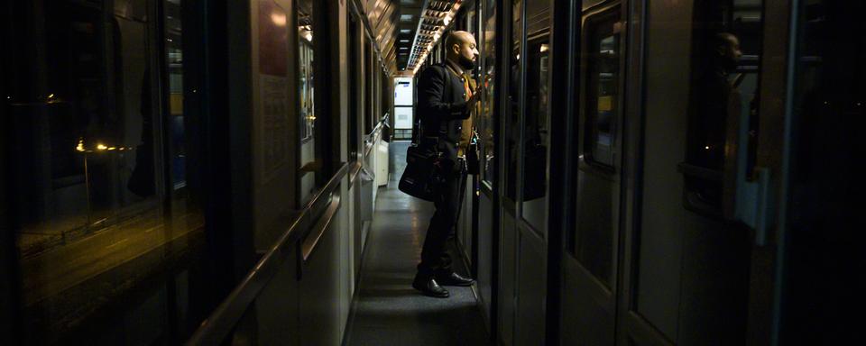 Un contrôleur inspecte un train de nuit autrichien qui relie les villes de Vienne et de Zürich. [Keystone - Leandre Duggan]