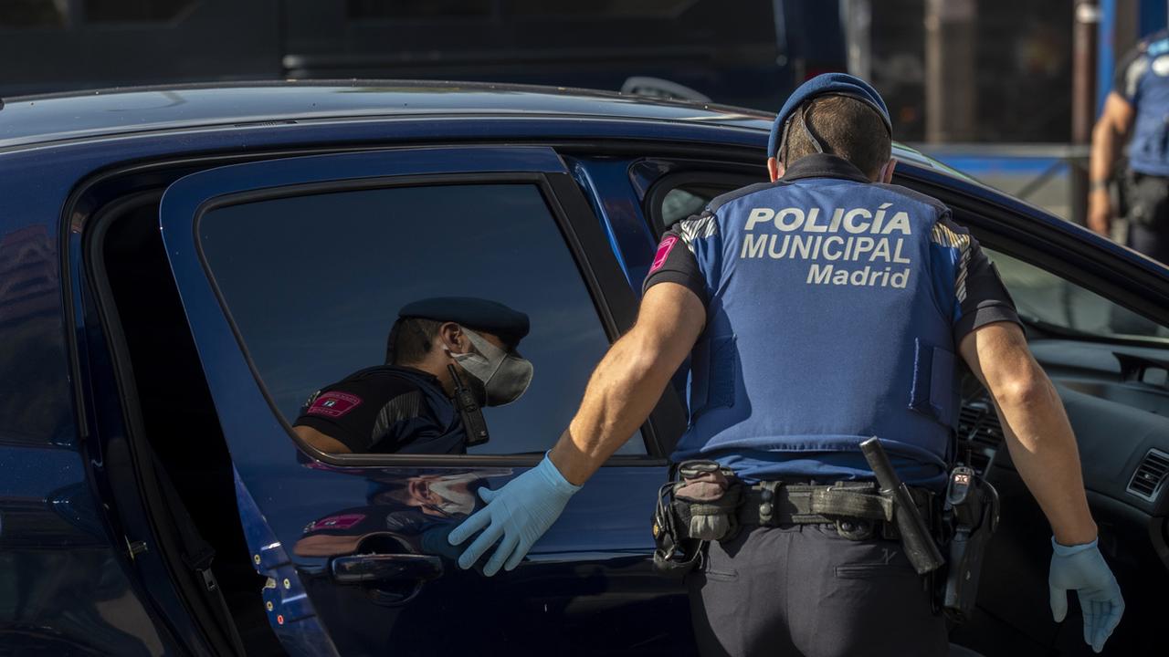 Un agente de la police locale arrête un véhicule à un point de contrôle dans le quartier d'Usera à Madrid, en Espagne, mardi 22 septembre 2020. [Keystone - AP Photo/Manu Fernandez]