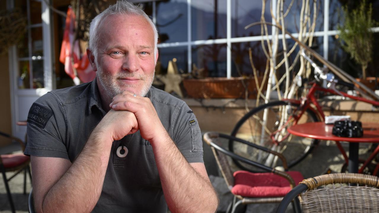 L'écrivain Marc Voltenauer en février 2023 sur la terrasse du Café de la Gare à Bex, à l'occasion de la sortie de son 5ème polar, "Cendres Ardentes". [Keystone - Laurent Gillieron]