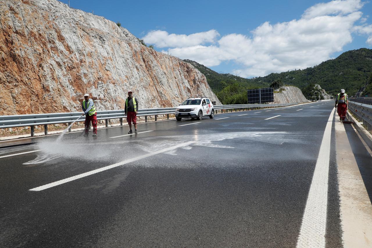 Des employés lavent la route lors de la journée d'ouverture d'un tronçon de 44 km sur l'autoroute Bar-Boljare, dans la municipalité de Podgorica, au Monténégro, le 13 juillet 2022. [reuters - Stevo Vasiljevic]