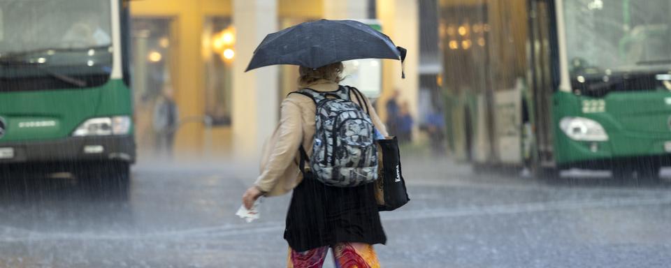 Une femme sous la pluie à Morges. [Keystone - Salvatore Di Nolfi]