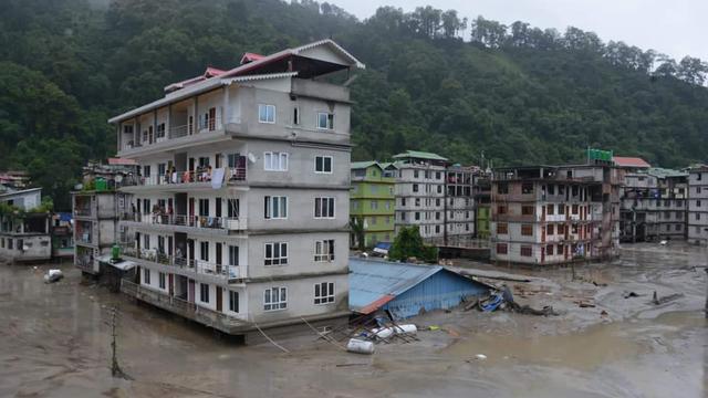 Au moins dix personnes sont mortes et 82 sont portées disparues à la suite de crues dans une vallée du nord-est de l'Inde, liées au débordement mercredi d'un lac glaciaire himalayen. [Keystone - AP Photo/Prakash Adhikari]