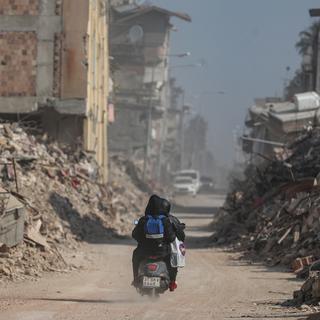 Jeudi 23 février: Des personnes passent sur une motocyclette devant des bâtiments effondrés à la suite de puissants tremblements de terre à Hatay, en Turquie. Plus de 46'000 personnes sont mortes après les séismes qui ont frappé le sud de la Turquie et le nord de la Syrie le 6 février et le 20 février. [Keystone - EPA/ERDEM SAHIN]