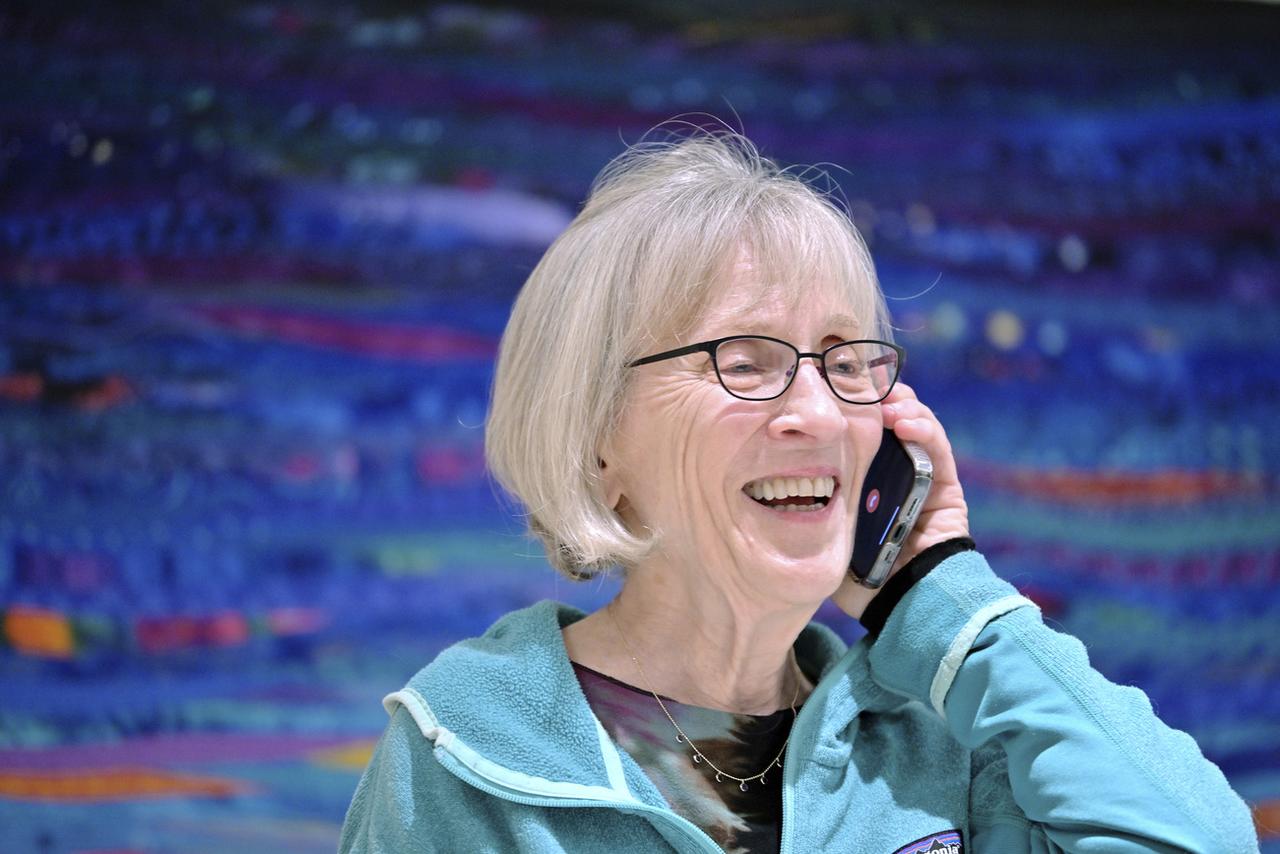 La professeure d'Harvard Claudia Goldin au téléphone dans sa maison, après avoir appris qu'elle avait reçu le prix Nobel d'Economie pour "avoir fait progresser la compréhension de l'évolution des femmes sur le marché du travail". Cambridge (Mass.), lundi 9 octobre 2023. [Keystone/AP photo - Josh Reynolds]