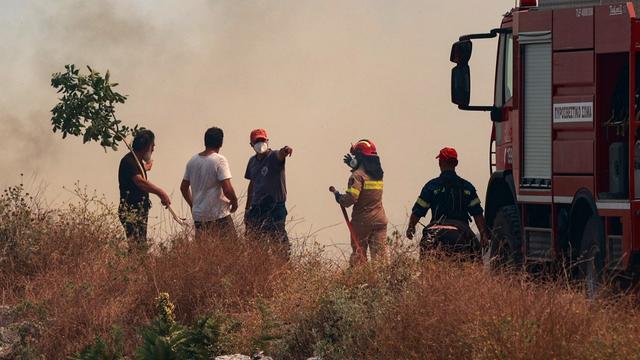 Des pompiers et des civils dans la fumée au nord de l'île de Corfou. [Eurokinissi / afp - Konotarinis Giorg]