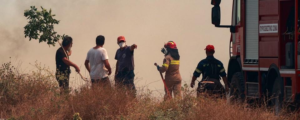 Des pompiers et des civils dans la fumée au nord de l'île de Corfou. [Eurokinissi / afp - Konotarinis Giorg]