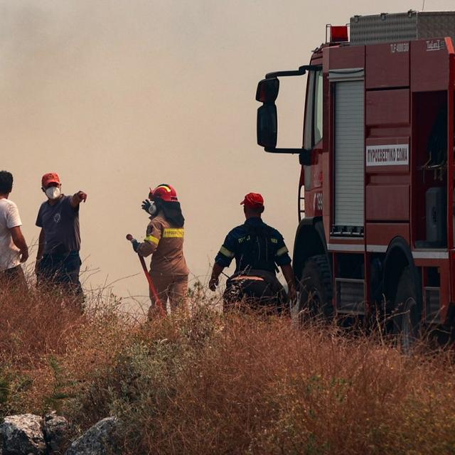 Des pompiers et des civils dans la fumée au nord de l'île de Corfou. [Eurokinissi / afp - Konotarinis Giorg]