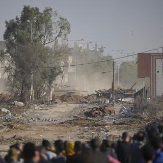 Des Palestiniens essayant de retourner au Nord de Gaza le premier jour de la trêve. [Keystone/AP Photo - Hatem Moussa]