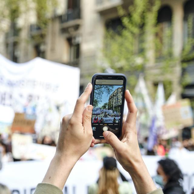 Buenos Aires, Argentine ; 24 septembre 2021 : Mains avec un téléphone portable prenant des photos de manifestants lors de la grève mondiale du climat. Concept : le rôle de la technologie et des réseaux sociaux dans les manifestations. [Depositphotos - ©Carolina_J]