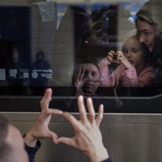 Nicolai, un père ukrainien de 41 ans, dit au revoir à sa fille Elina, 4 ans, et à sa femme Lolita qui fuient la guerre d'invasion russe en Ukraine pour se réfugier en Pologne. [Keystone/AP Photo - Emilio Morenatti]