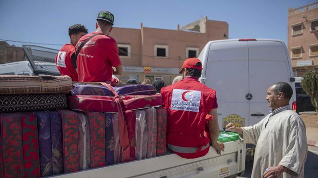 Maroc: des volontaires du Croissant-Rouge distribuent des matelas à ceux qui ont perdu leur maison dans le séisme, à Amizmiz, le 10 septembre. [Keystone - Jalal Morchidi/EPA]