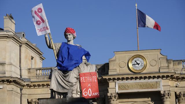 La statue de la loi est habillée d'un poster demandant la retraite à 60 ans, en marge de la grève contre l'élévation de la retraite en France. [Keystone/AP Photo - Christophe Ena]