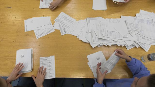 Des bulletins sont dépouillés dans un bureau de vote à Berne, lors des élections fédérales de 2019. [Keystone - Peter Klaunzer]