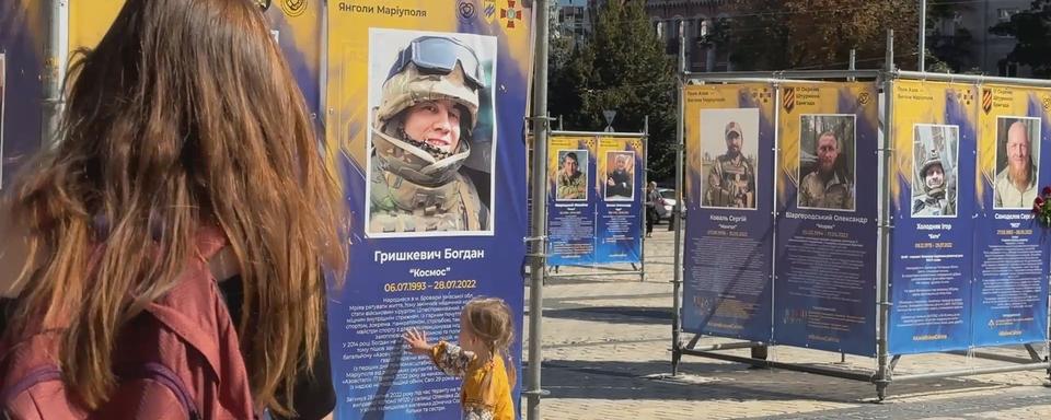 La petite Solomia, accompagnée de sa maman Yulia, devant la photo de son papa Bogdan, mort au front. [RTS - Maurine Mercier]