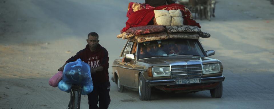 Des Palestiniens avec leurs possessions, fuyant les bombardements de l'armée israélienne sur Khan Younès dans la bande de Gaza. [AP/Keystone - Mohammed Dahman]