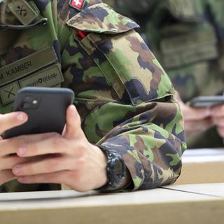Des recrues de l'armée suisse devant leur téléphone. [Keystone - Laurent Gillieron]