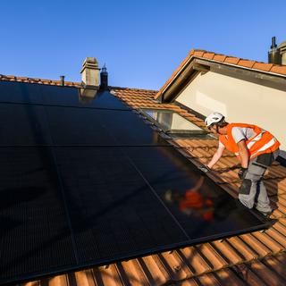 Fribourg demande aux citoyens de participer aux frais d'installation de panneaux solaires. [Keystone - Jean-Christophe Bott]