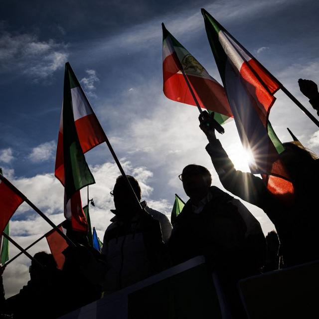 Des manifestants brandissent le drapeau iranien d'avant la Révolution islamique devant l'ONU à Genève le 24 novembre 2022 (photo d'illustration). [AFP - Valentin Flauraud]