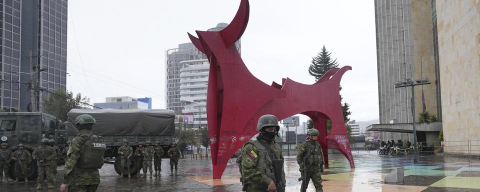 Des soldats gardent la zone de la télévision équatorienne avant le débat présidentiel, le 13 août, à Quito. [Keystone - Dolores Ochoa/AP Photo]