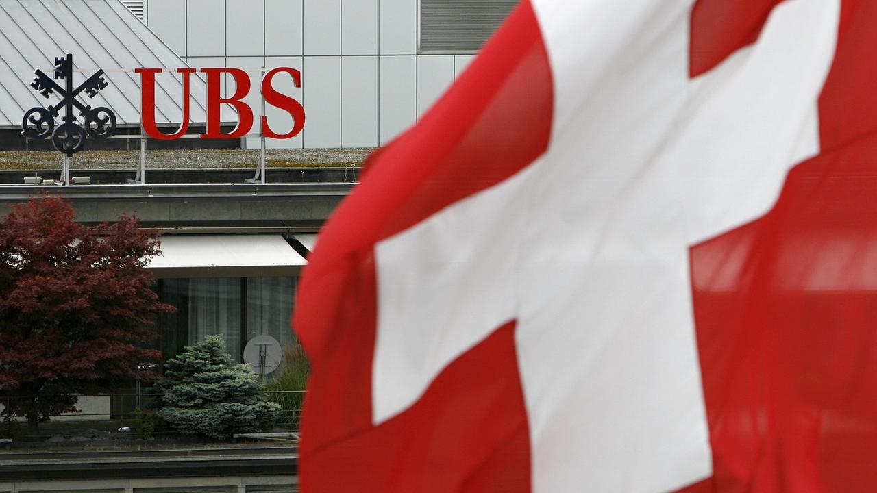 Le logo d'UBS derrière un drapeau suisse, à Zurich. [Keystone - Alessandro Della Bella]