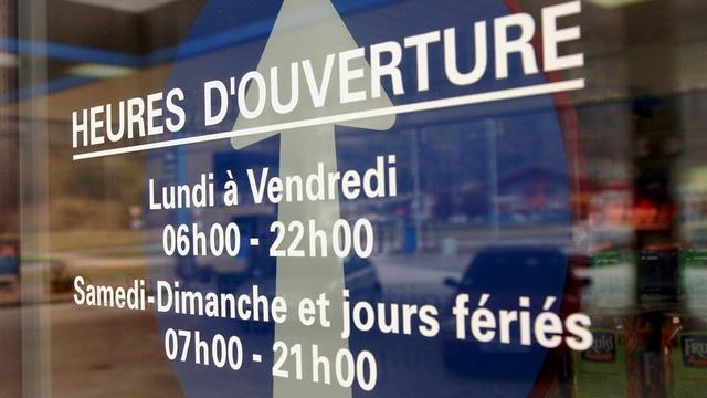 Le référendum contre l'extension de l'ouverture des magasins a abouti en Valais. Image d'illustration d'un horaire affiché sur la porte d'un magasin à Sion en 2002. [Keystone - Andree-Noelle Pot]
