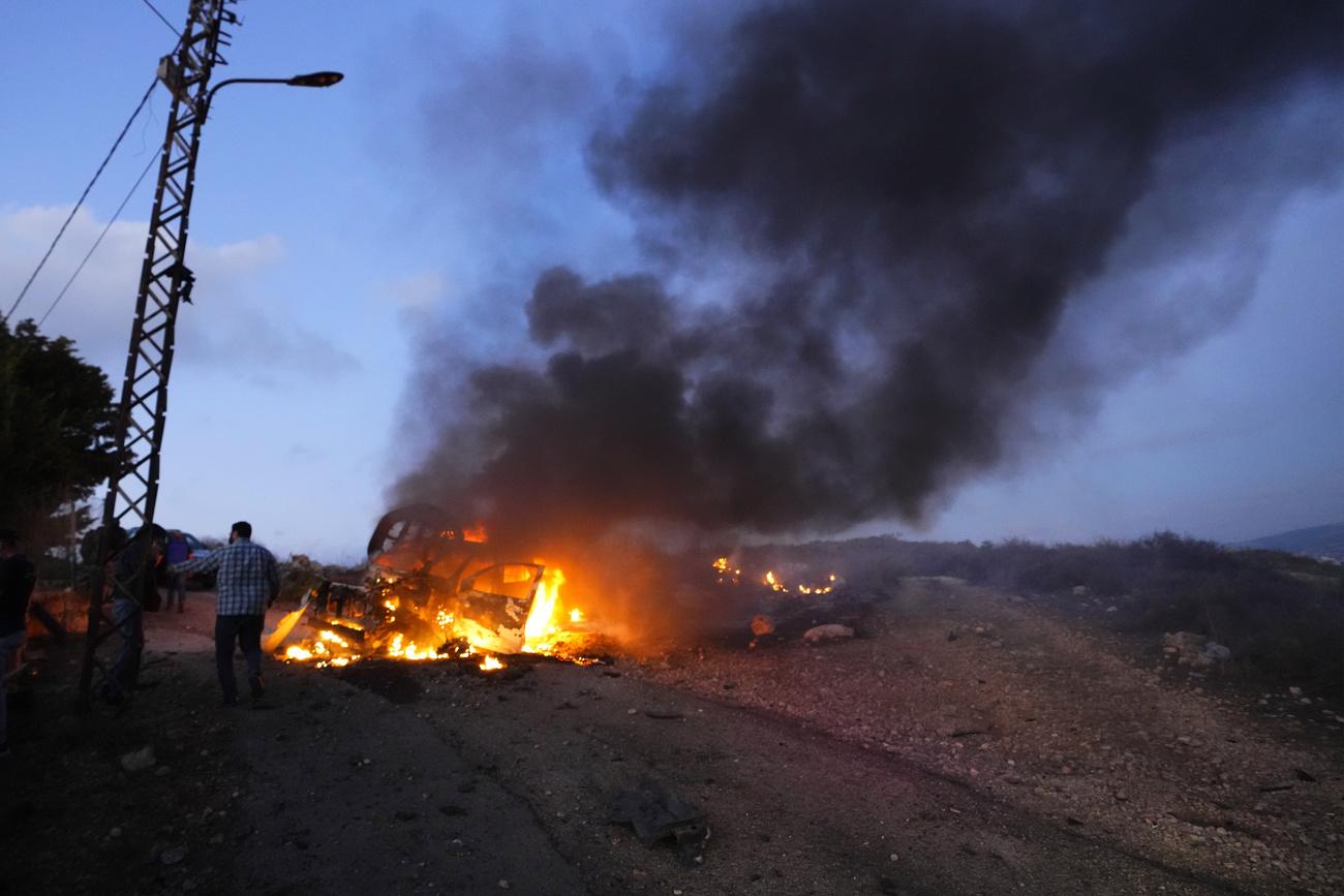 Le véhicule d'un journaliste brûle après avoir été ciblé dans un bombardement au sud du Liban. [Keystone - AP Photo/Hassan Ammar]