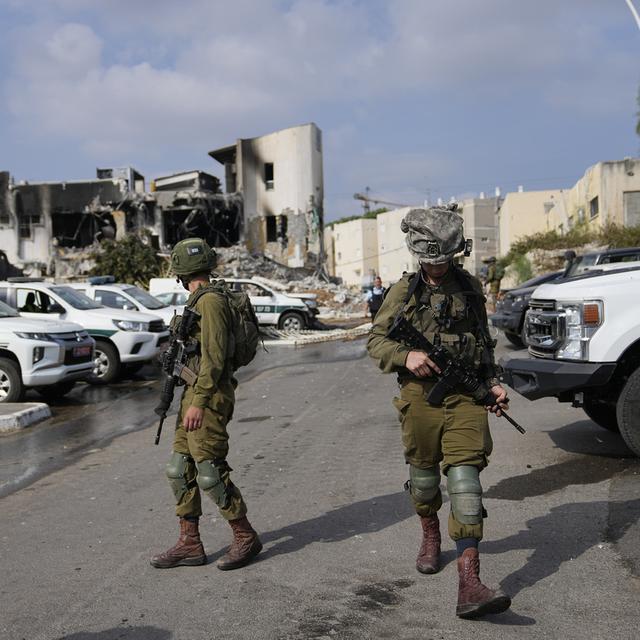 Des soldats israéliens marchent près du poste de police qui a été envahi par des militants du Hamas samedi, à Sderot, Israël, dimanche 8 octobre 2023. [Keystone - AP Photo/Ohad Zwigenberg]