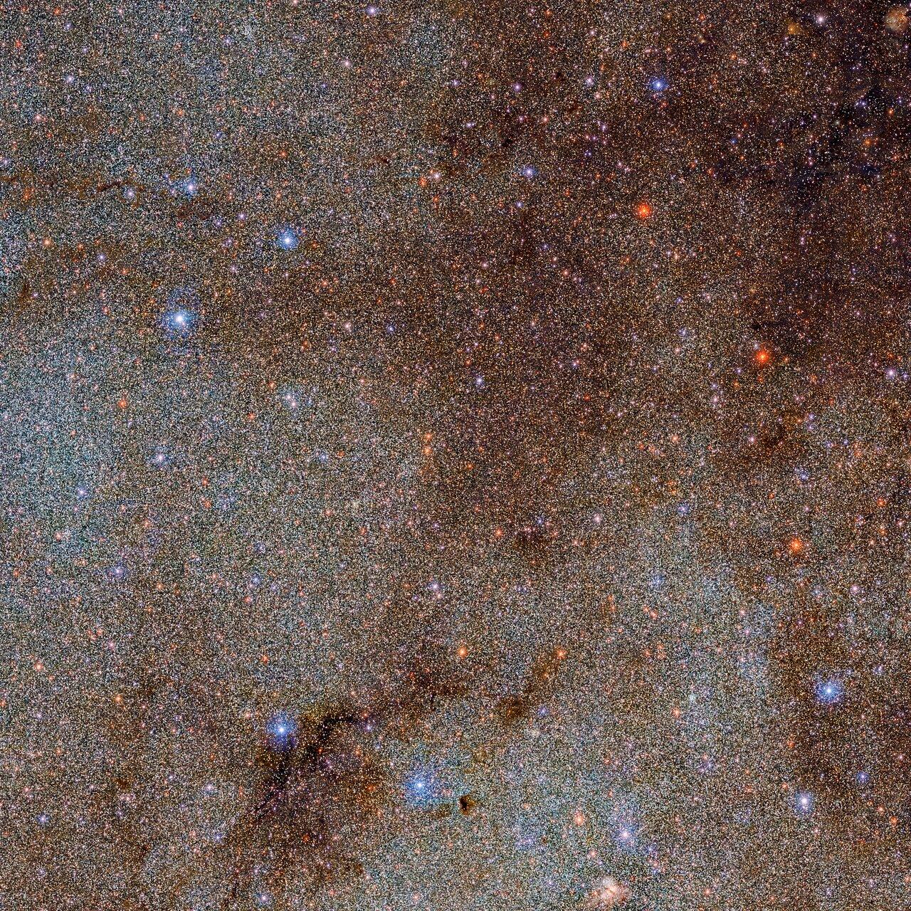 Cette image, qui regorge d'étoiles et de nuages de poussière sombres, n'est qu'un petit extrait – une tête d'épingle! – de l'ensemble de l'étude DECaPS2 (Dark Energy Camera Plane Survey) de la Voie lactée. [DECaPS2/DOE/FNAL/DECam/CTIO/NOIRLab/NSF/AURA - M. Zamani & D. de Martin (NSF’s NOIRLab)]