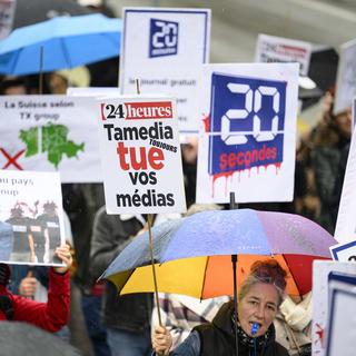 Des journaliste de Tamedia Suisse romande brandissent des pancartes lors d'une manifestation le 31 octobre 2023. [Keystone - Laurent Gillieron]