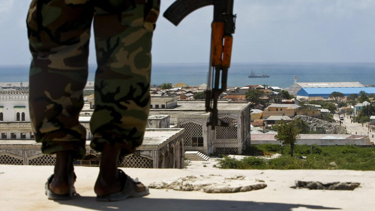 Un soldat de l'armée somalienne face à la ville portuaire de Harardhere. [EPA - Dai Kurokawa]