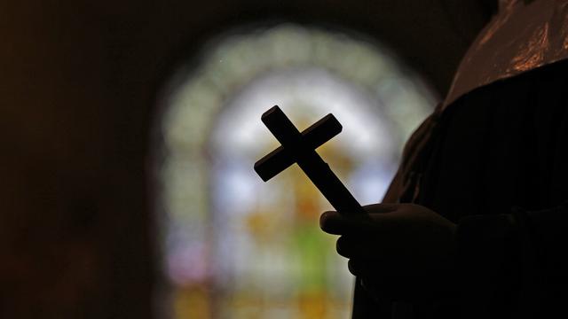 La silhouette d'un crucifix et un vitrail à l'intérieur d'une église catholique de la Nouvelle-Orléans. (image d'illustration) [AP Photo/Keystone - Gerald Herbert]