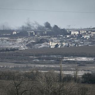 De la fumée s'élève de Soledar pilonnée par les artilleries russe et urkainienne. [Keystone/AP Photo - Libkos]