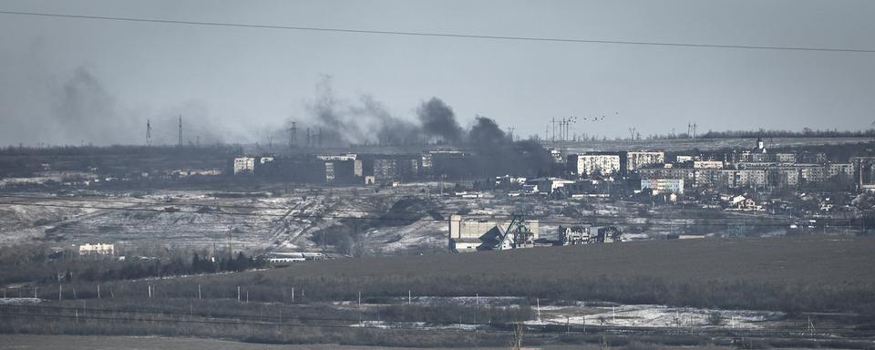 De la fumée s'élève de Soledar pilonnée par les artilleries russe et urkainienne. [Keystone/AP Photo - Libkos]