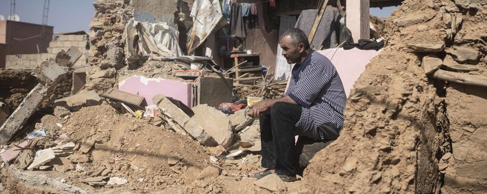 Un homme sur les ruines de sa maison à Amizmiz, près de Marrakech. [Keystone/AP - Mosa'ab Elshamy]