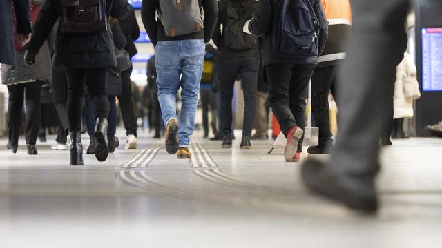 Des personnes déambulant en gare de Berne. [Keystone - Christian Beutler]