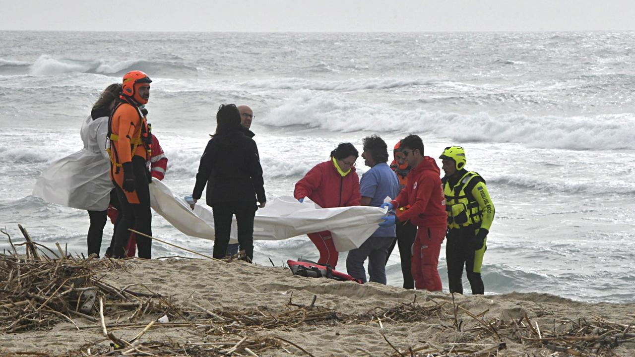 Des pompiers italiens et du personnel de la Croix-Rouge sur le site du naufrage de l'embarcation transportant des migrants, dont au moins 40 ont perdu la vie. [EPA/Keystone - Giuseppe Pipita]