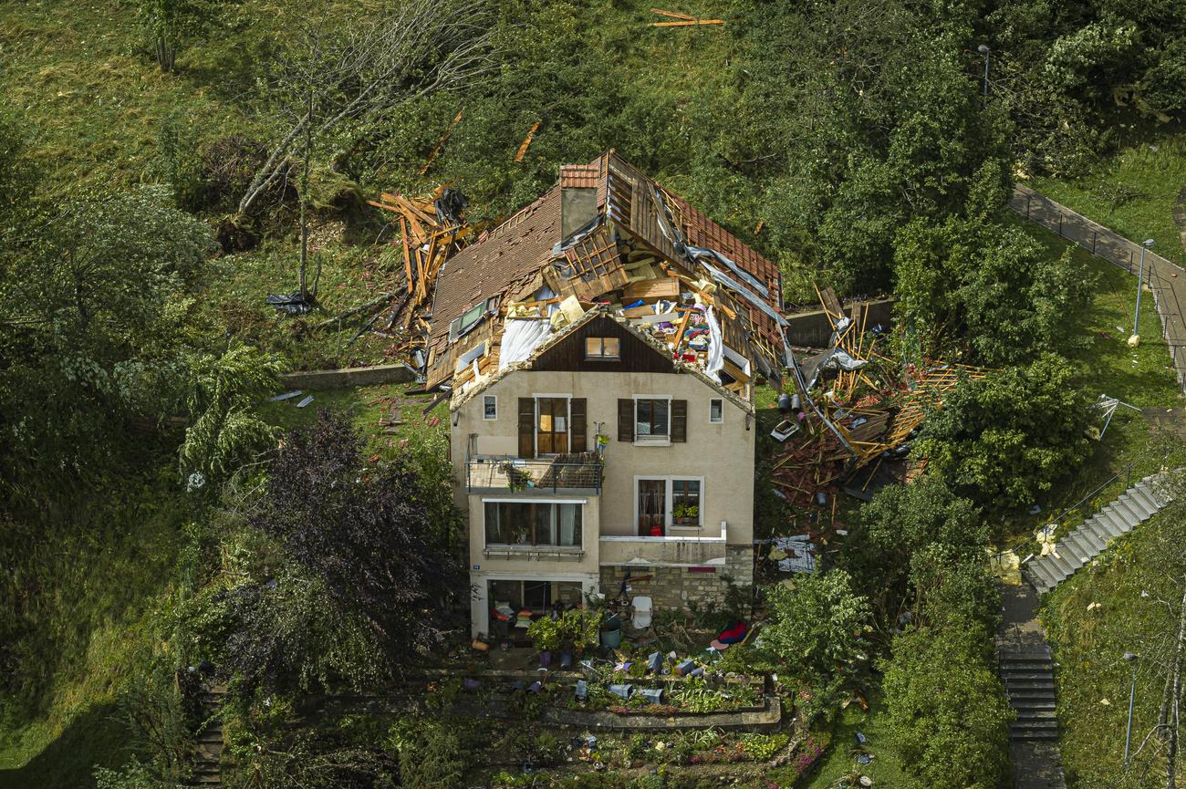 Une maison accidentée avec un toit retourné par la tornade qui a touché la ville de La Chaux-de-Fonds, 24 juillet 2023. [Keystone - Valentin Flauraud]