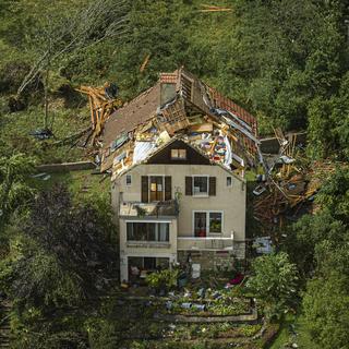 Une maison accidentée avec un toit retourné par la tornade qui a touché la ville de La Chaux-de-Fonds, 24 juillet 2023. [Keystone - Valentin Flauraud]