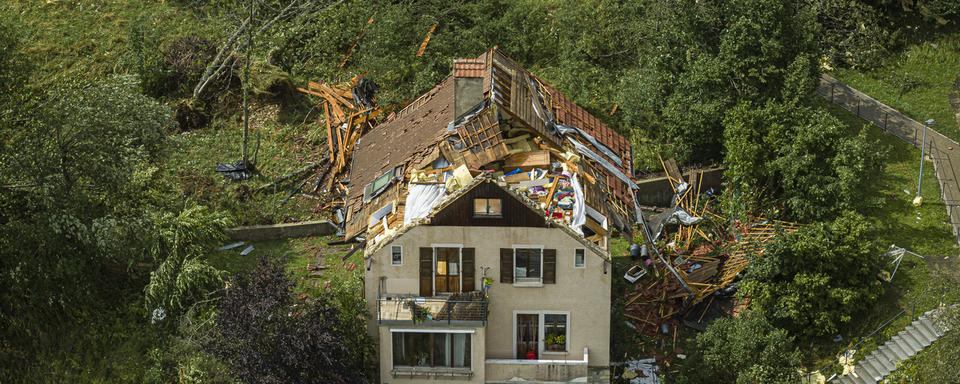 Une maison accidentée avec un toit retourné par la tornade qui a touché la ville de La Chaux-de-Fonds, 24 juillet 2023. [Keystone - Valentin Flauraud]