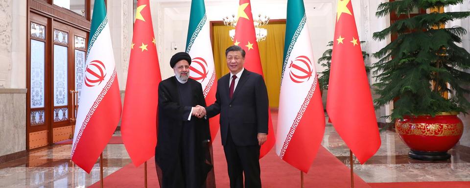 Le président iranien Ebrahim Raïssi et le président chinois Xi Jinping se serrent la main lors de la cérémonie d'accueil d'Ebrahim Raïssi à Pékin, en Chine, le 14 février 2023. [Keystone - Bureau présidentiel iranien / EPA]