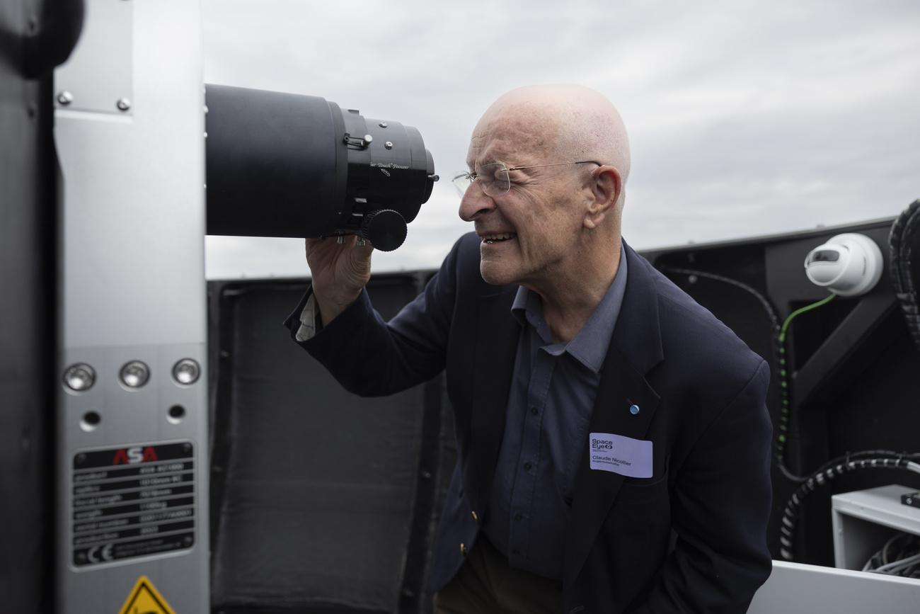 L'ambassadeur du projet et astronaute Claude Nicollier regarde dans le télescope du nouvel l'observatoire Space Eye à Niedermuhlern (BE). [Keystone - Peter Klaunzer]