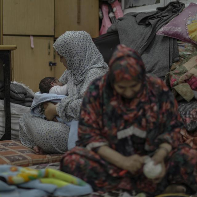 Deux femmes palestiniennes et un bébé dans un refuge d'une école des Nations Unies à Gaza, 22 octobre 2023. [Keystone/EPA - Haitham Imad]