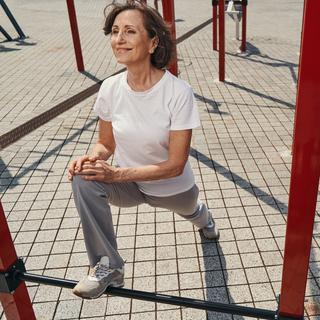 Merry mature female exercising with horizontal bars. Femme senior faisant du sport en extérieur. [Depositphotos - ©svitlanahulko85.gmail.com]