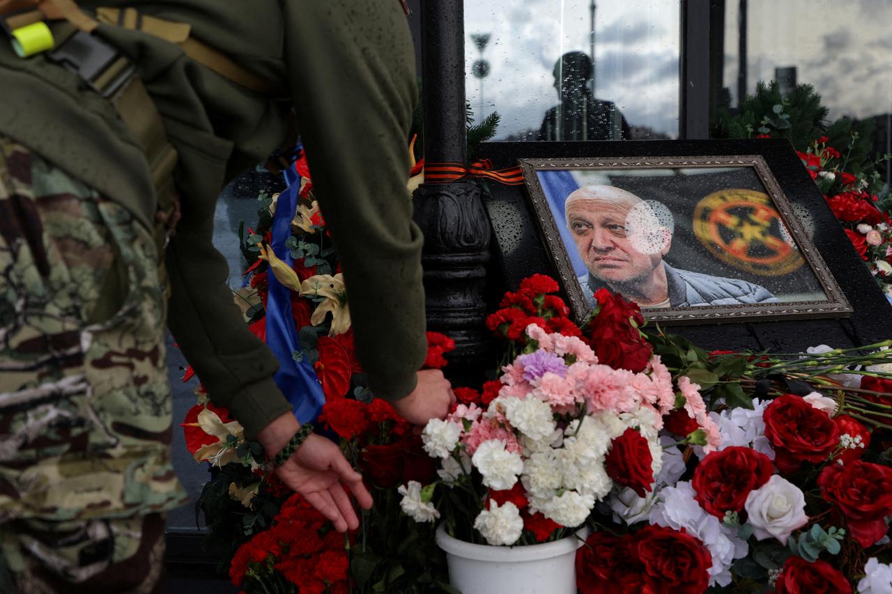 Un homme dépose des fleurs sur un mémorial en l'honneur d'Evgueni Prigojine, chef du groupe de mercenaires Wagner, tout en célébrant les 40 jours de sa mort pour respecter une tradition orthodoxe, à Saint-Pétersbourg, le 1er octobre 2023. [reuters - Anton Vaganov]