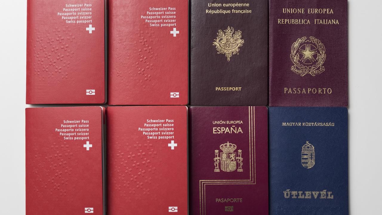 Quatre passeports suisses et un passeport européen français, italien et espagnol, ainsi qu'un ancien passeport hongrois non européen, photographiés le 2 décembre 2016 (image d'illustration). [keystone - Christian Beutler]