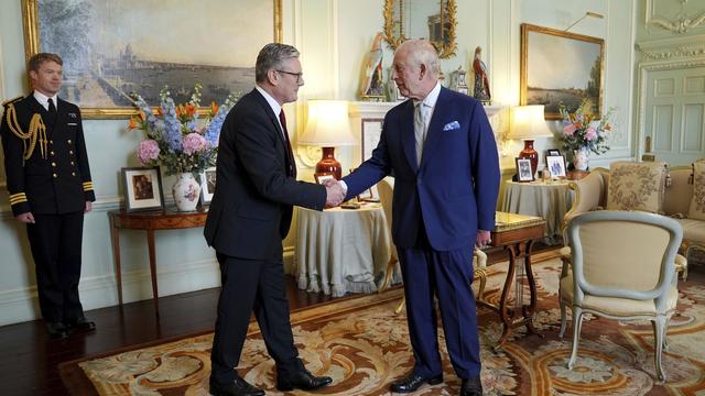 Le roi Charles III de Grande-Bretagne, à droite, serre la main de Keir Starmer après avoir invité le chef du Parti travailliste à devenir premier ministre et à former un nouveau gouvernement, le vendredi 5 juillet 2024. [Pool Photo via AP - Keystone - Yui Mok]