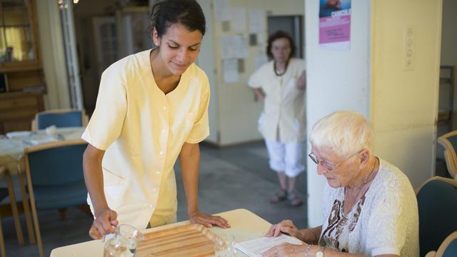 Lucie, une infirmiere, donne de l'eau a boire a Charlotte, une personne agee de l'Etablissement Medico-Social, EMS, "Le Marronnier", ce jeudi 25 juillet 2013 a Lutry. Un avis de canicule est lance par meteo suisse, une vague de chaleur se produira durant ces prochains jours. (KEYSTONE/Jean-Christophe Bott) [Keystone - Jean-Christophe Bott]