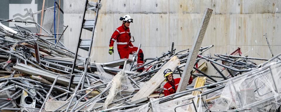 Les services de secours travaillent suite à l'effondrement d'un échafaudage à Prilly. [Keystone - Jean-Christophe Bott]