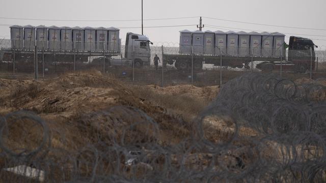 Des camions d'aide entre Kerem Shalom et l'Égypte. [Keystone/AP Photo - Leo Correa]